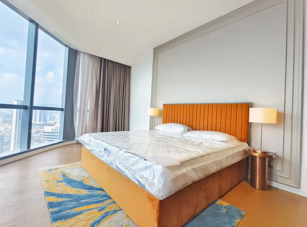 Bedroom features: king-size bed with upholstered headboard, two bedside lamps, area rug with abstract pattern, floor-to-ceiling windows, curtains, wooden flooring, decorative wall paneling, city view; style: modern; view: city.